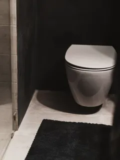 Witte toilet naast een douche in een moderne badkamer